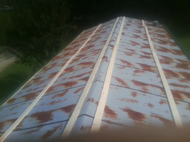 Rusted metal roof panels with new wood purlins before replacement — Storm Damage Roof Repair in Crane by Roofing Brothers