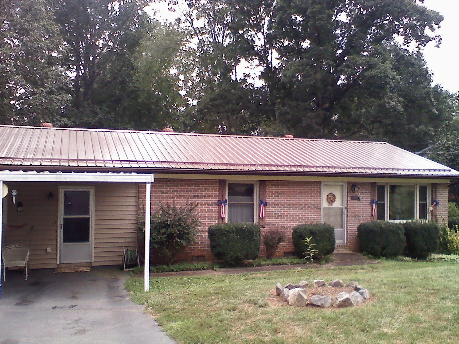 Bronze metal roof and carport on a brick ranch home — Roof Repair work by our crew in Crane
